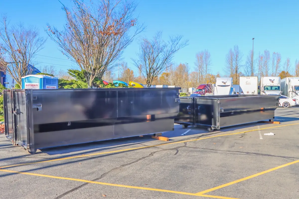 Professional dumpster rental service with roll-off container on residential driveway in Athens